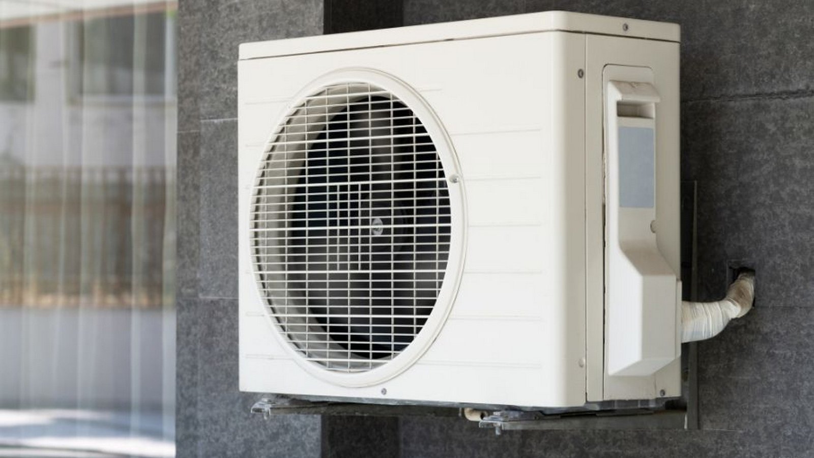 HVAC outdoor unit under cloudy sky in a suburban Southern California home