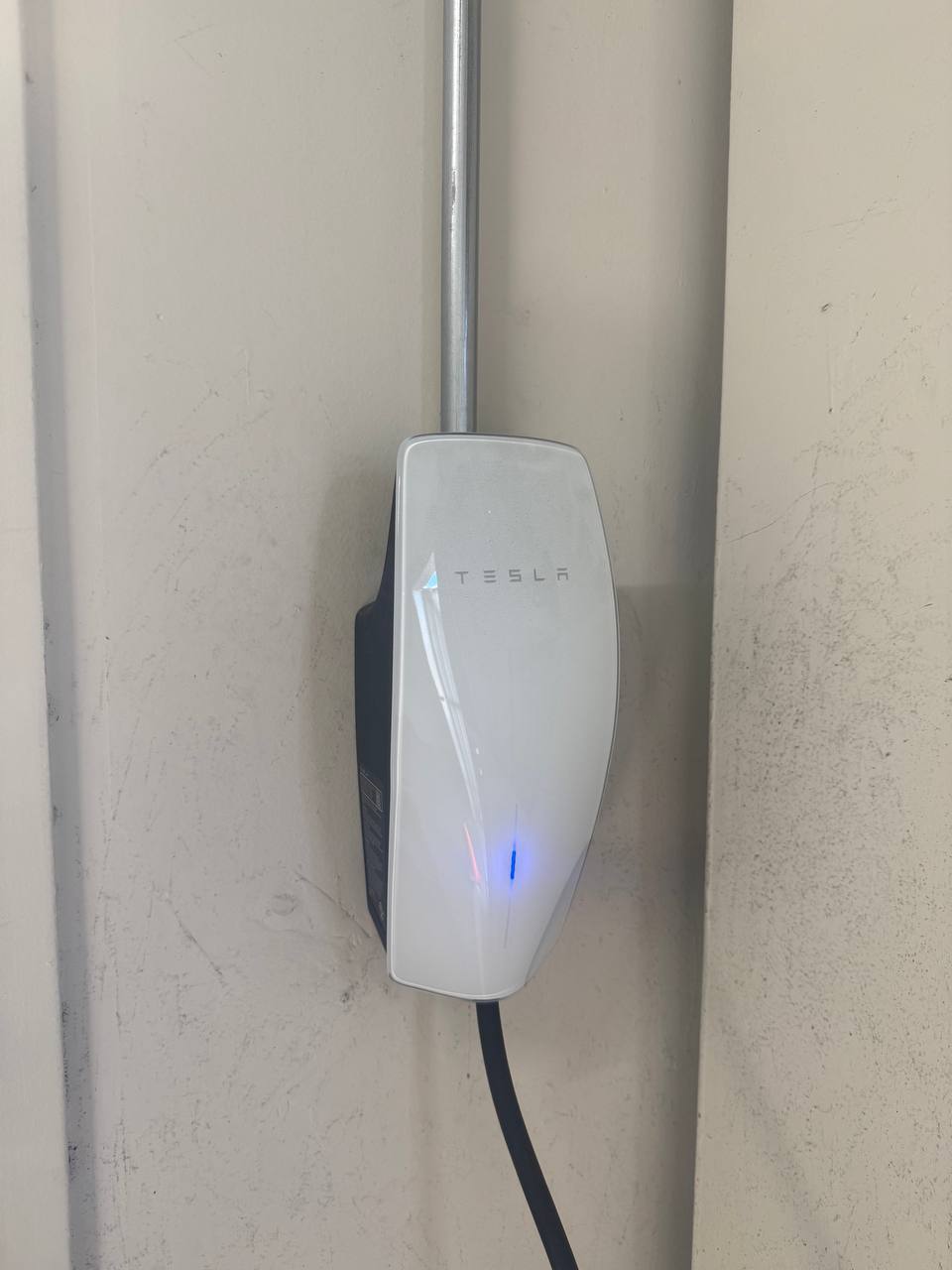 Tesla Wall Connector installed on a garage wall by Smartchoice